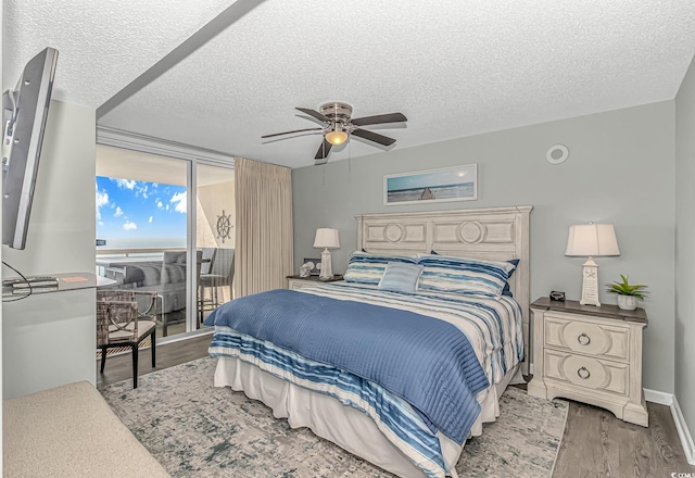 bedroom with a ceiling fan, access to exterior, a textured ceiling, baseboards, and light wood-style floors