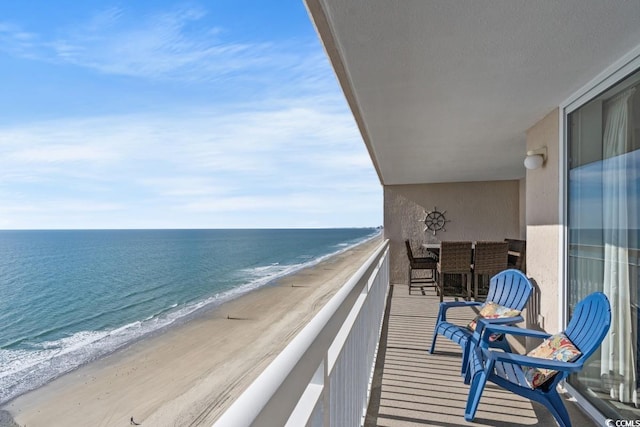 balcony featuring a water view and a beach view