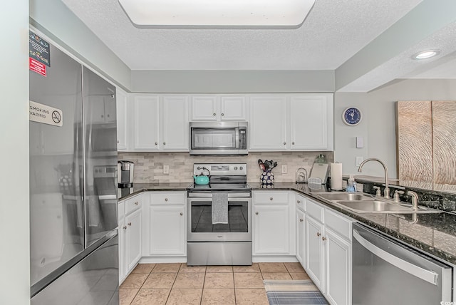 kitchen featuring a textured ceiling, stainless steel appliances, white cabinetry, and a sink