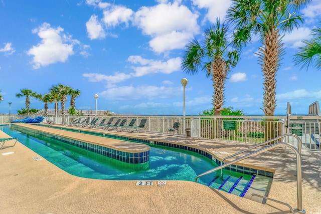 community pool featuring fence and a patio