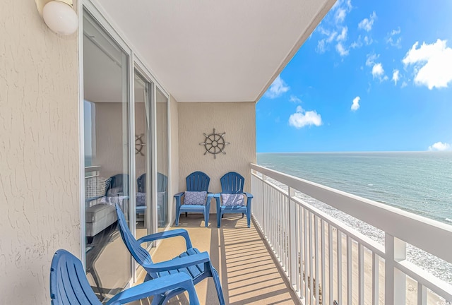 balcony featuring a water view and a view of the beach