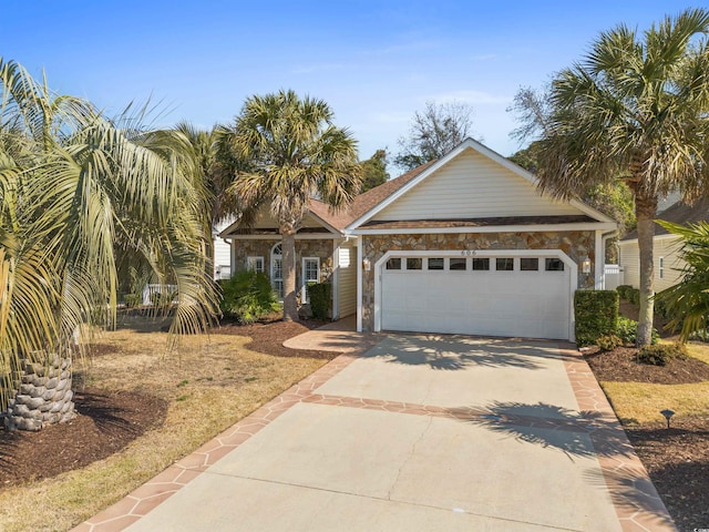 view of front of property featuring stone siding, concrete driveway, and a garage