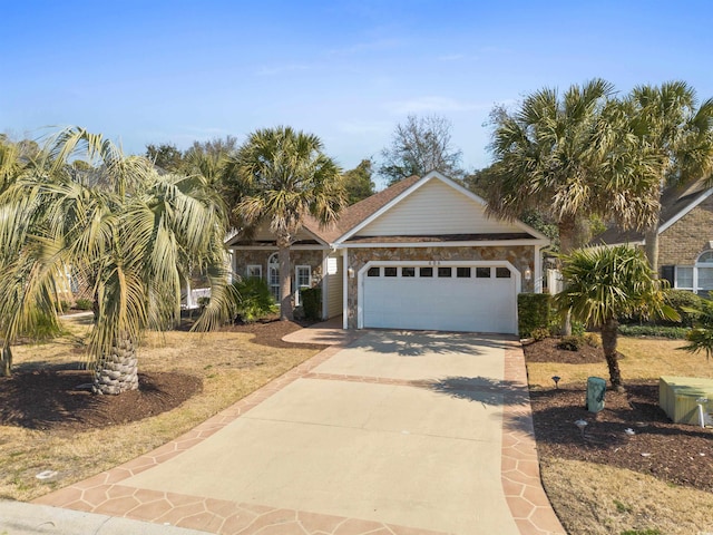 view of front of property with driveway, stone siding, and an attached garage