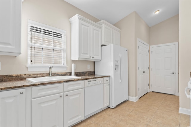 kitchen with white appliances, white cabinets, a sink, and light tile patterned flooring