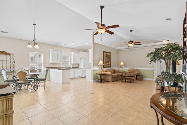 living area with lofted ceiling, light tile patterned flooring, and visible vents