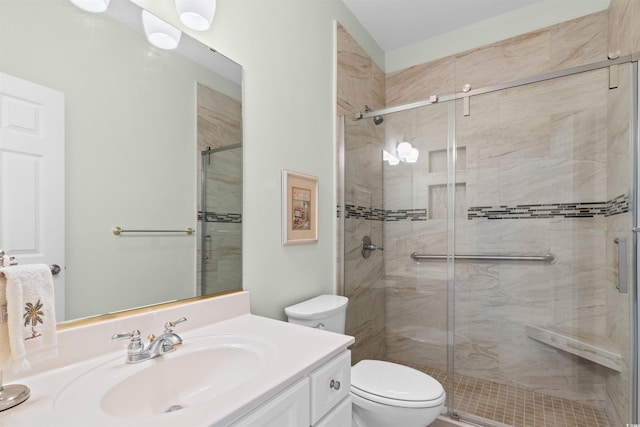 bathroom featuring vanity, a shower stall, and toilet