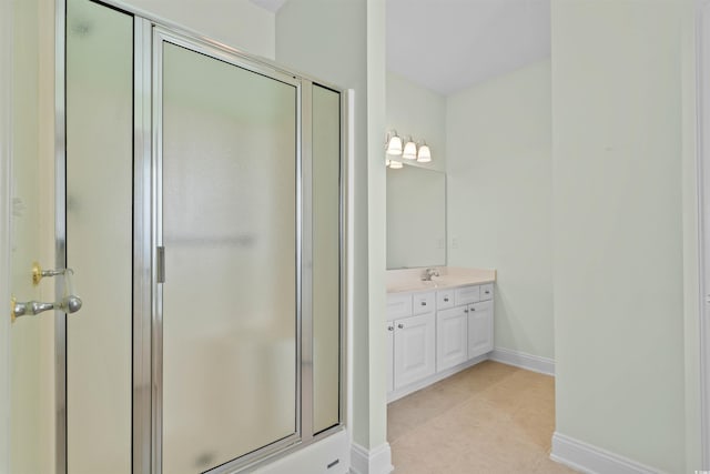 full bath featuring a stall shower, tile patterned flooring, vanity, and baseboards