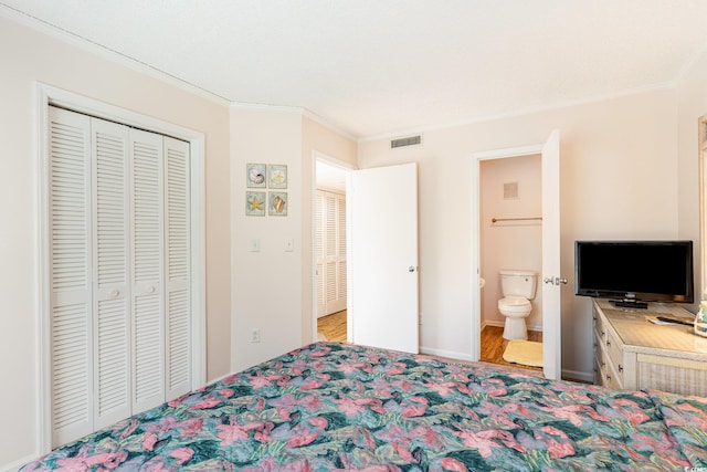 bedroom featuring ornamental molding, a closet, visible vents, and ensuite bathroom