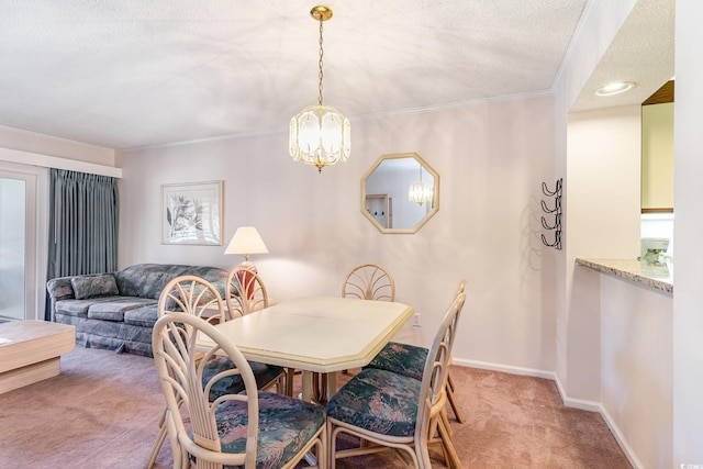 dining area featuring a textured ceiling, a notable chandelier, light colored carpet, baseboards, and ornamental molding