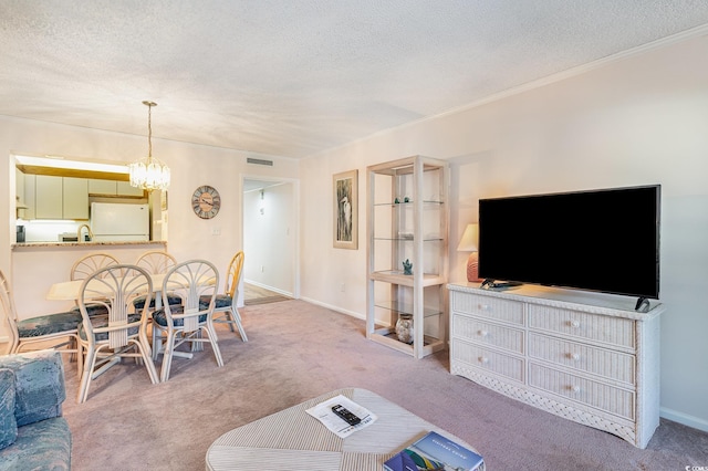 living room with a textured ceiling, carpet floors, baseboards, and an inviting chandelier