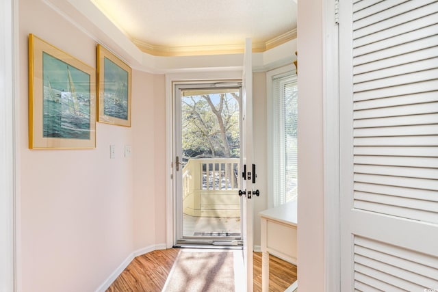 entryway featuring ornamental molding, baseboards, and wood finished floors