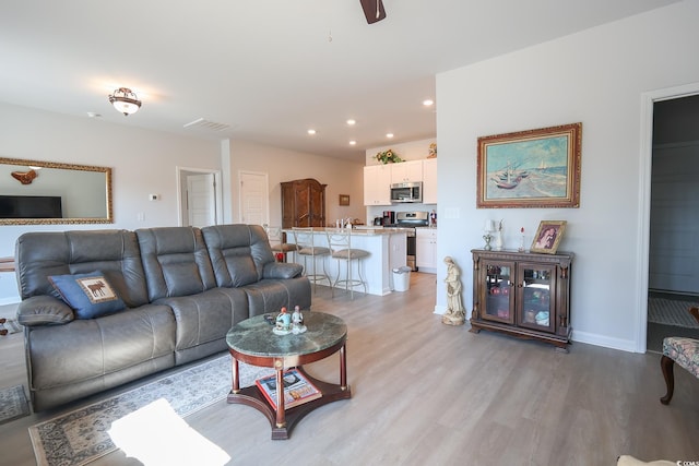 living room featuring recessed lighting, visible vents, light wood finished floors, and baseboards