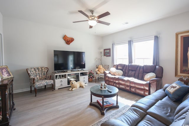 living room featuring visible vents, baseboards, ceiling fan, and wood finished floors