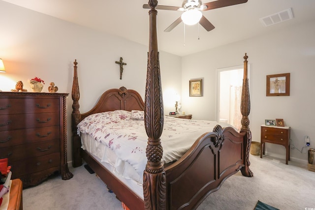 bedroom with visible vents, light colored carpet, and ceiling fan