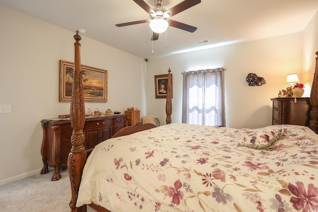 bedroom with visible vents, baseboards, light colored carpet, and ceiling fan