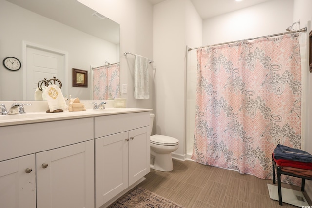 full bathroom featuring a sink, toilet, a shower with shower curtain, and double vanity