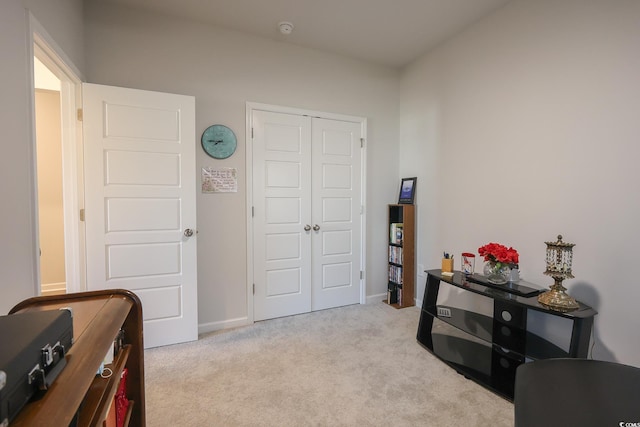 interior space featuring baseboards and light carpet