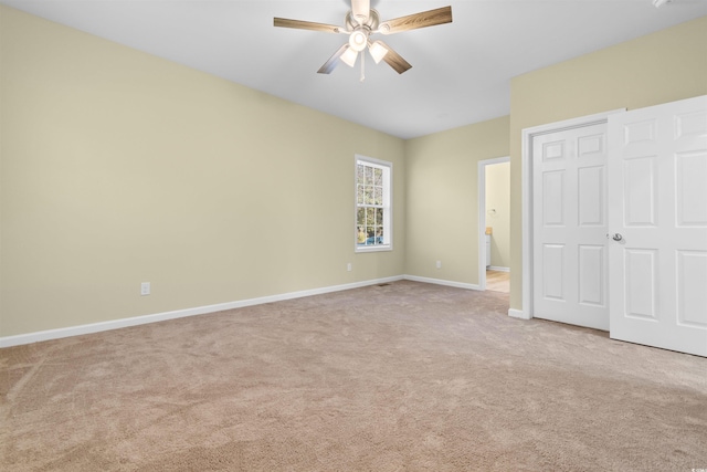 unfurnished bedroom featuring light carpet, ceiling fan, baseboards, and a closet