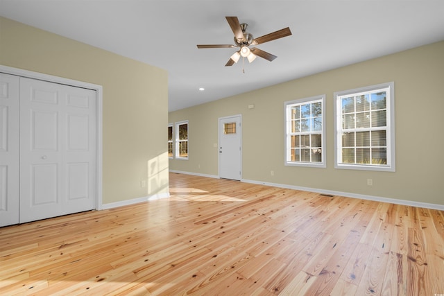 unfurnished living room featuring baseboards, a ceiling fan, and light wood-style floors