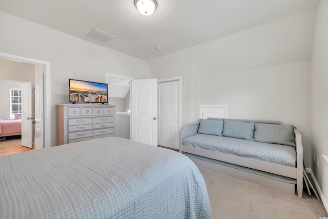 carpeted bedroom featuring vaulted ceiling, a closet, connected bathroom, and visible vents