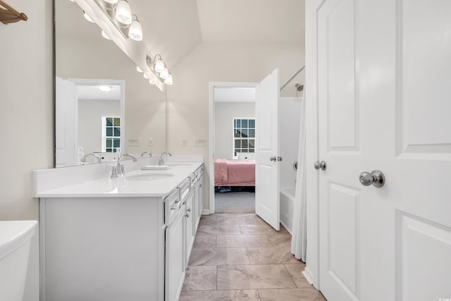 bathroom featuring marble finish floor, double vanity, a sink, and toilet