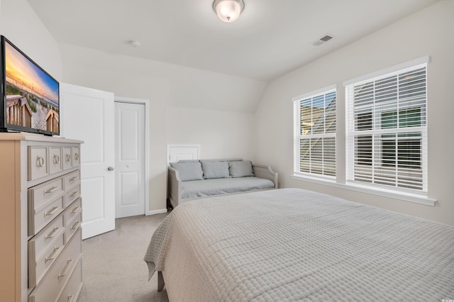 bedroom with light carpet, lofted ceiling, and visible vents