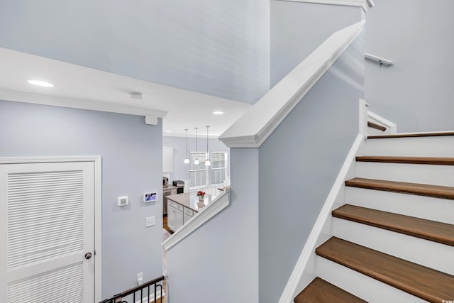 staircase with ornamental molding and recessed lighting