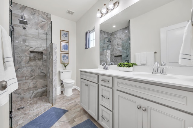 bathroom with double vanity, visible vents, tiled shower, toilet, and a sink