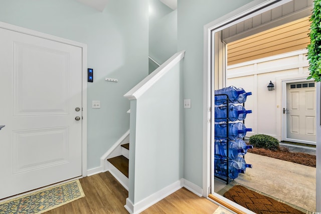 foyer featuring stairs, wood finished floors, and baseboards