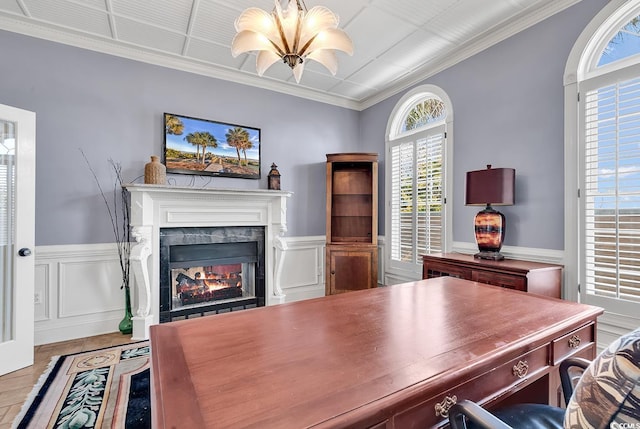 office space featuring a high end fireplace, a wainscoted wall, a notable chandelier, and ornamental molding