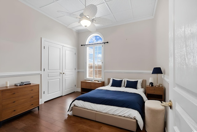 bedroom featuring ceiling fan, a closet, wood finished floors, and ornamental molding