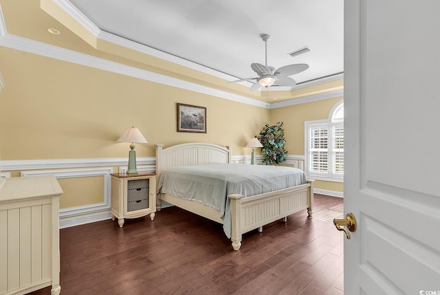 bedroom featuring a wainscoted wall, a tray ceiling, and visible vents