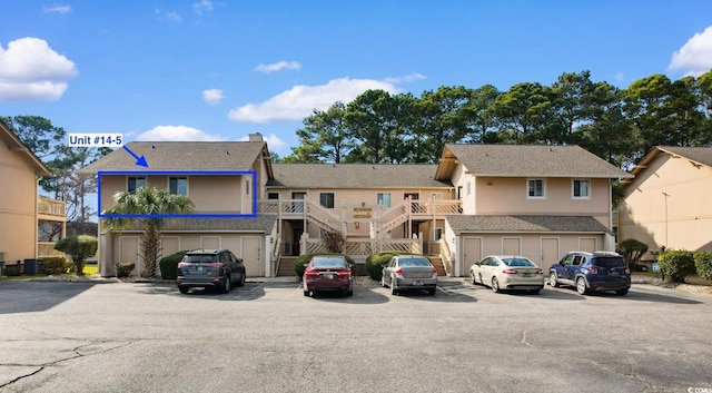 view of building exterior featuring uncovered parking and stairway