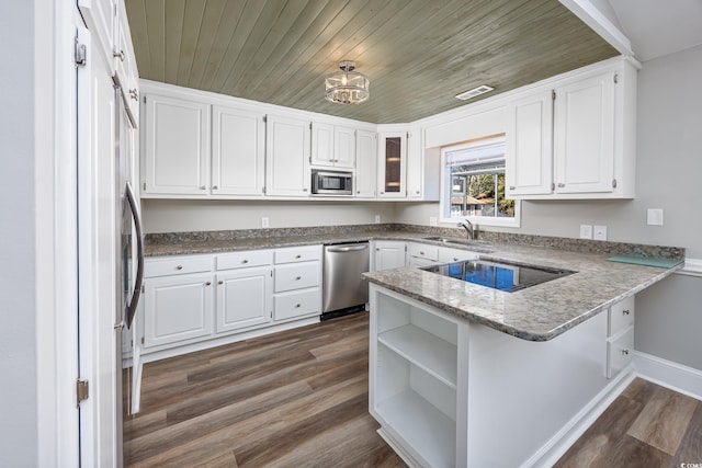 kitchen with dark wood-style flooring, stainless steel appliances, white cabinets, a sink, and a peninsula