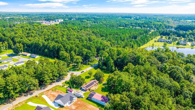 birds eye view of property with a water view and a view of trees