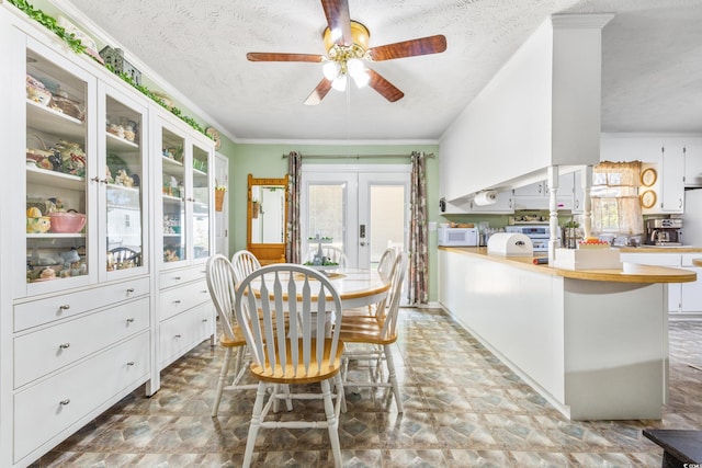 dining space with french doors, crown molding, a textured ceiling, and ceiling fan