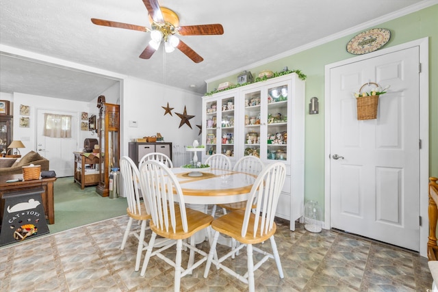 dining space with ceiling fan and ornamental molding