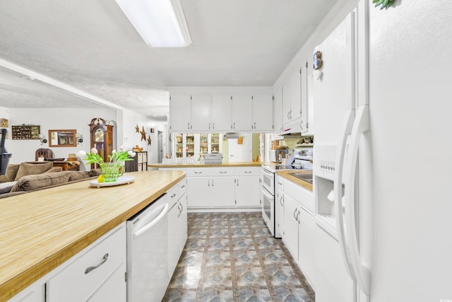 kitchen featuring white appliances, white cabinets, wood counters, and open floor plan