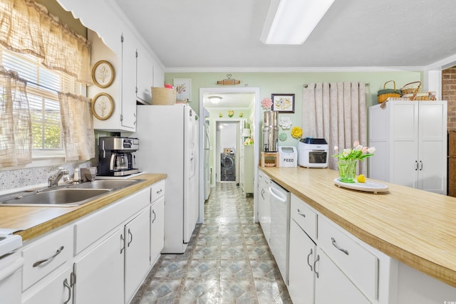 kitchen featuring light countertops, white appliances, a sink, and white cabinetry