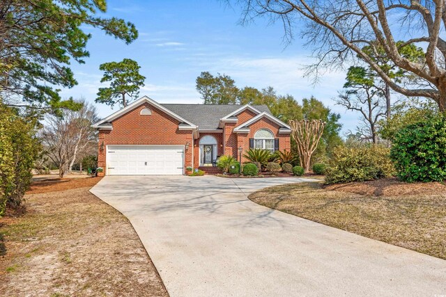 view of front of home featuring a garage, concrete driveway, and brick siding