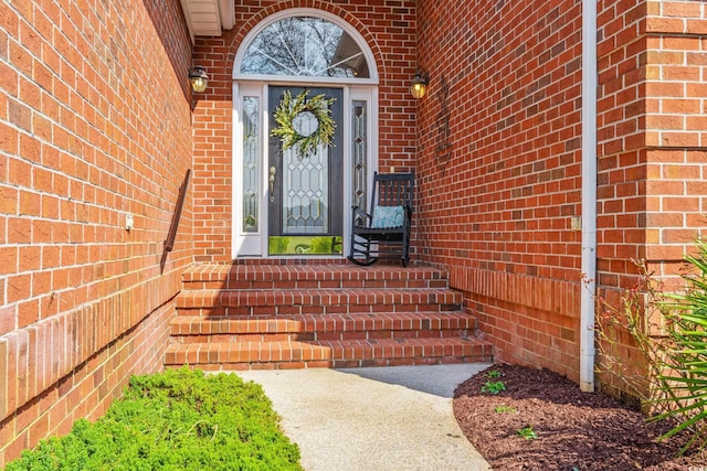 doorway to property with brick siding