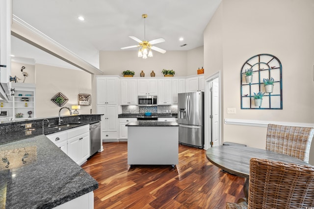 kitchen featuring stainless steel appliances, dark wood-style flooring, white cabinetry, and a sink