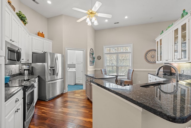 kitchen featuring dark wood-style flooring, washer / clothes dryer, appliances with stainless steel finishes, glass insert cabinets, and white cabinets