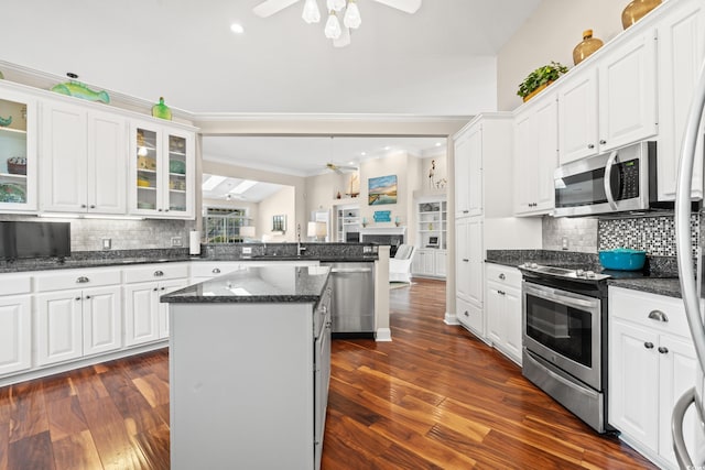 kitchen featuring ceiling fan, appliances with stainless steel finishes, a peninsula, crown molding, and white cabinetry