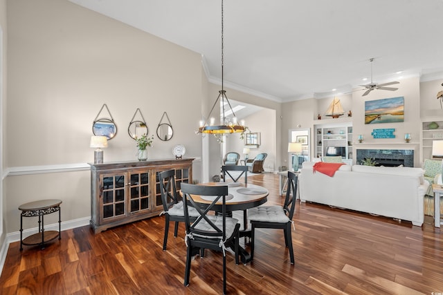 dining room with crown molding, ceiling fan with notable chandelier, a fireplace, and wood finished floors