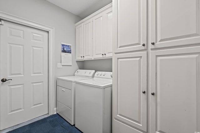 clothes washing area with washing machine and dryer and cabinet space