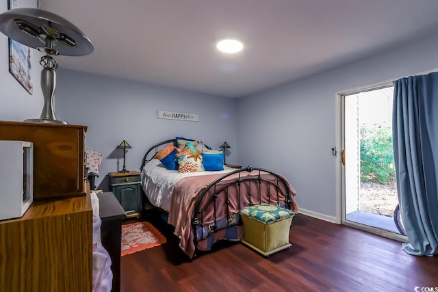 bedroom featuring access to exterior, baseboards, and wood finished floors