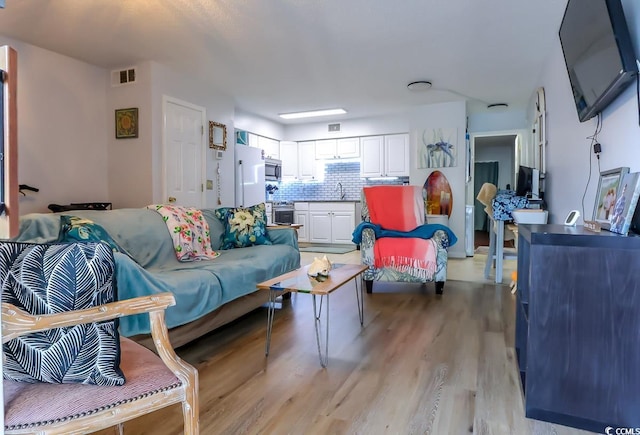 living area featuring visible vents and light wood-type flooring