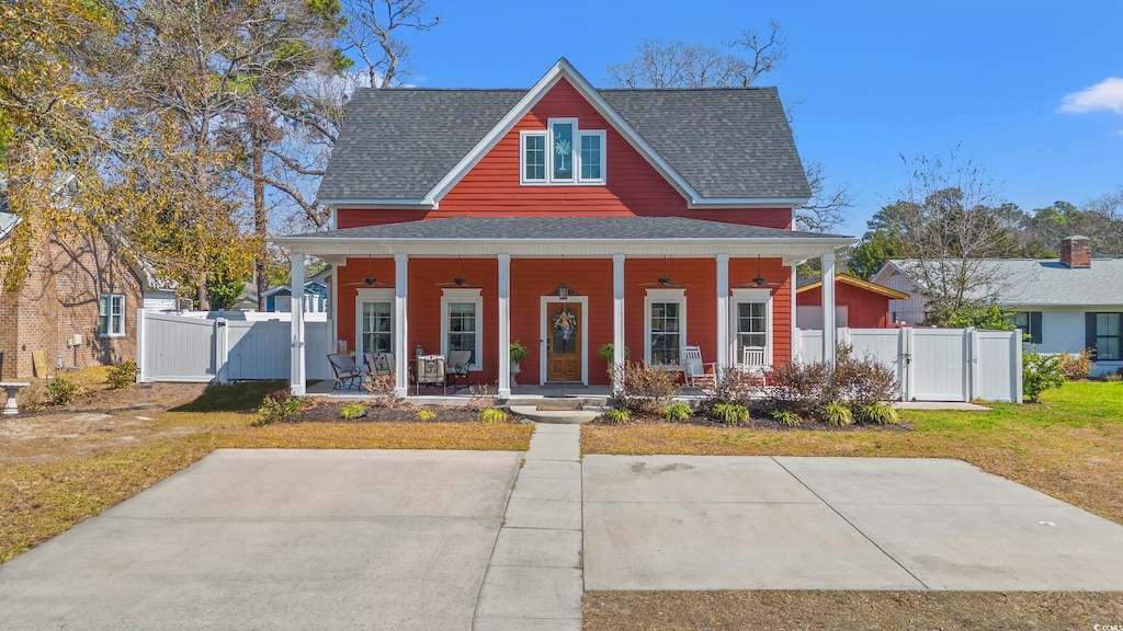 1608 25th Ave N, North Myrtle Beach, SC 29582 - view of front facade with covered porch, roof with shingles, fence, and a gate