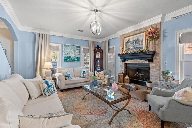 living room featuring ornamental molding, a wealth of natural light, a fireplace, and arched walkways